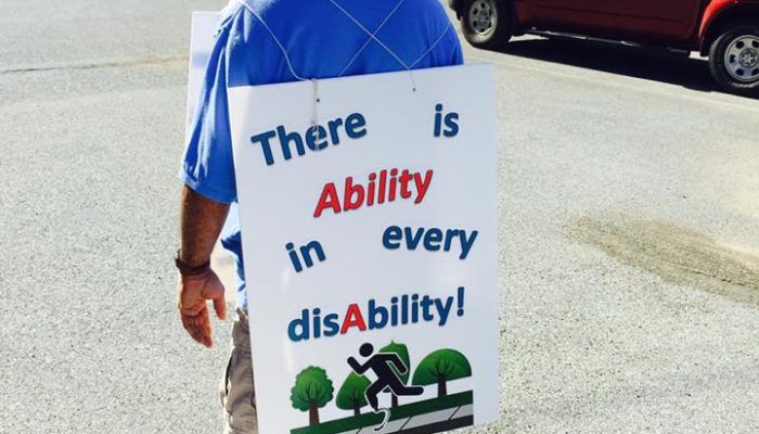 person with a big sign that says there is ability in every disability